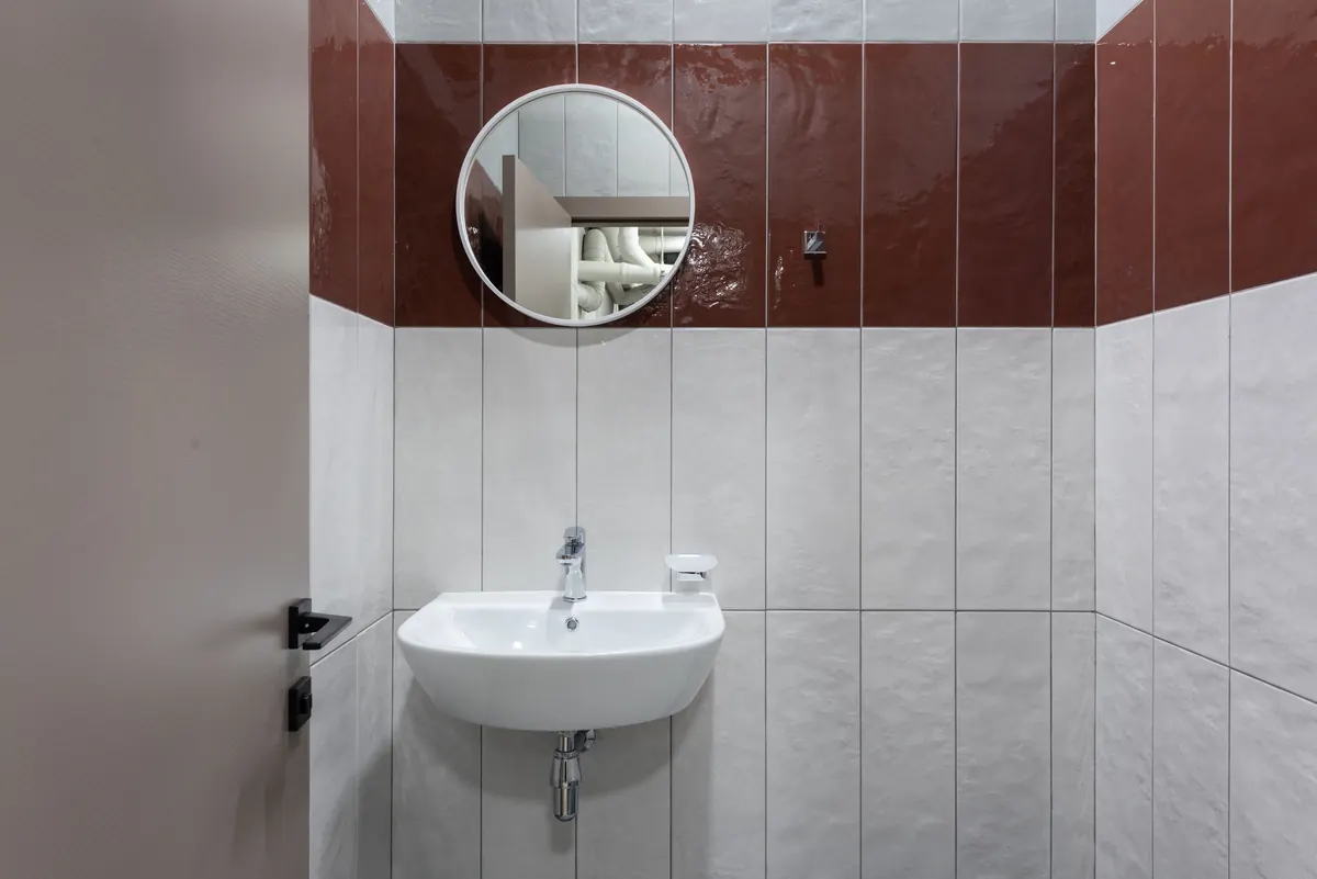 Existing public washroom with basin and wall mirror