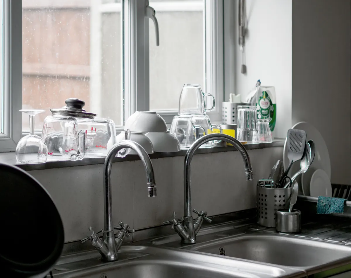 Multiple sink faucets arranged by a kitchen basin