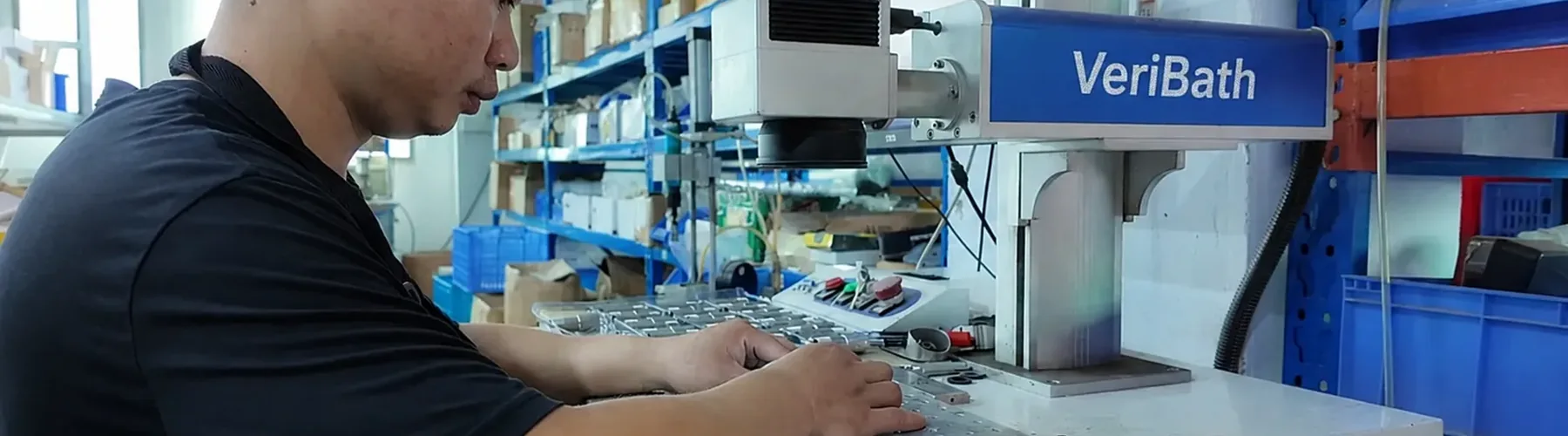 VeriBath technician laser-marking bathroom hardware components for an OEM order